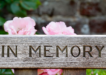 In Memory sign with flowers in background.